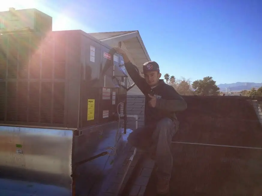 HVAC technician performing HVAC Inspection on a rooftop unit in St. Albans
